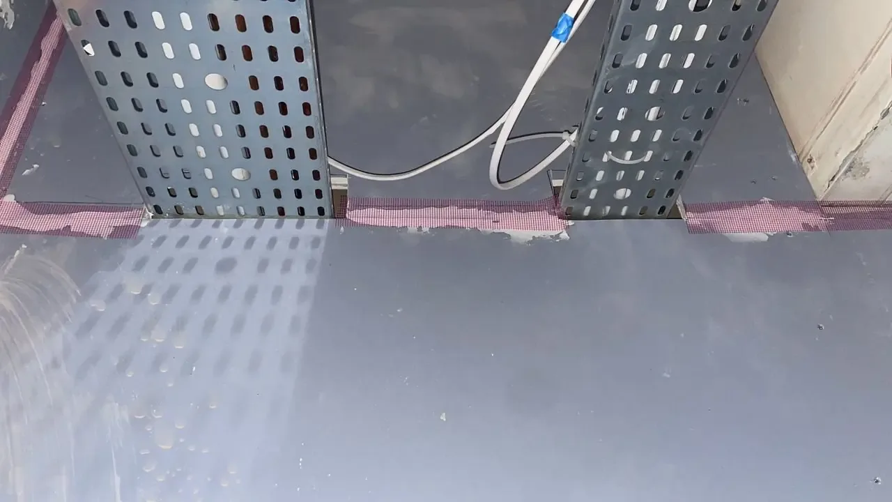 Cable tray fire stopping — Manchester, Didsbury M20: cable trays at a wall opening with pink sealant around the perimeter.