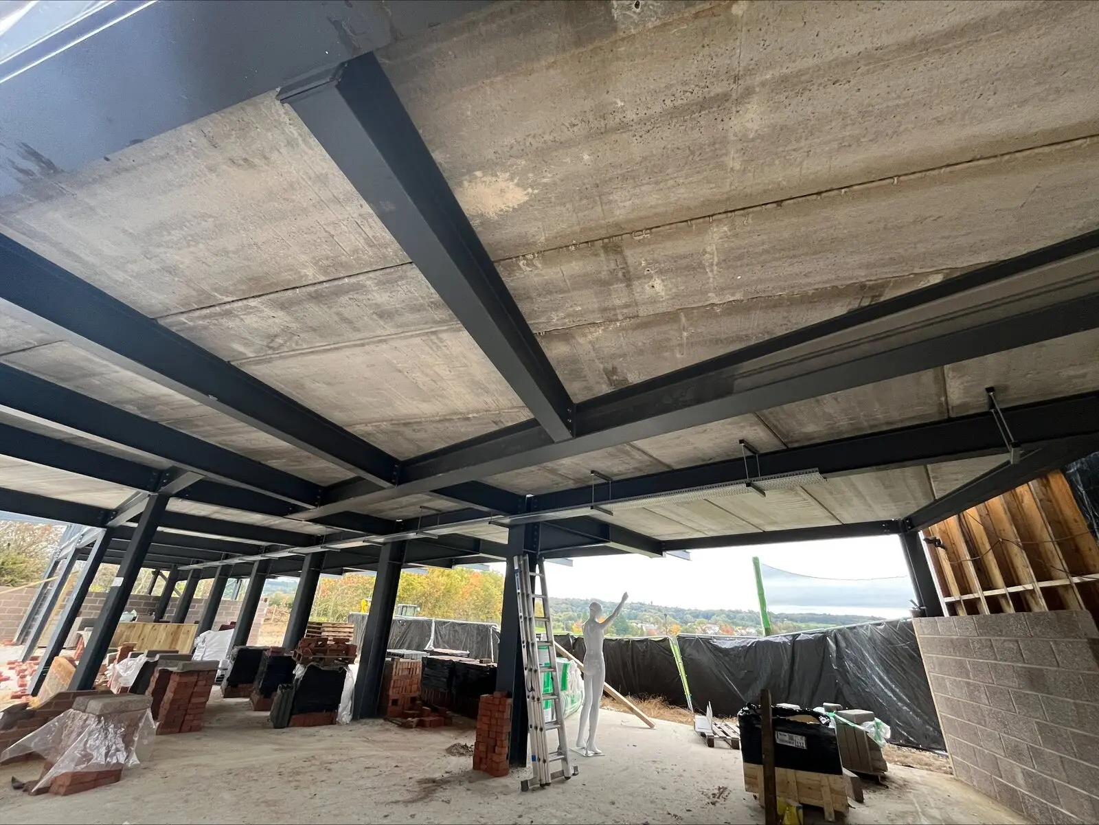 Intumescent paint structural steel — Manchester, Withington M20: dark-coated steel beams inside a building.