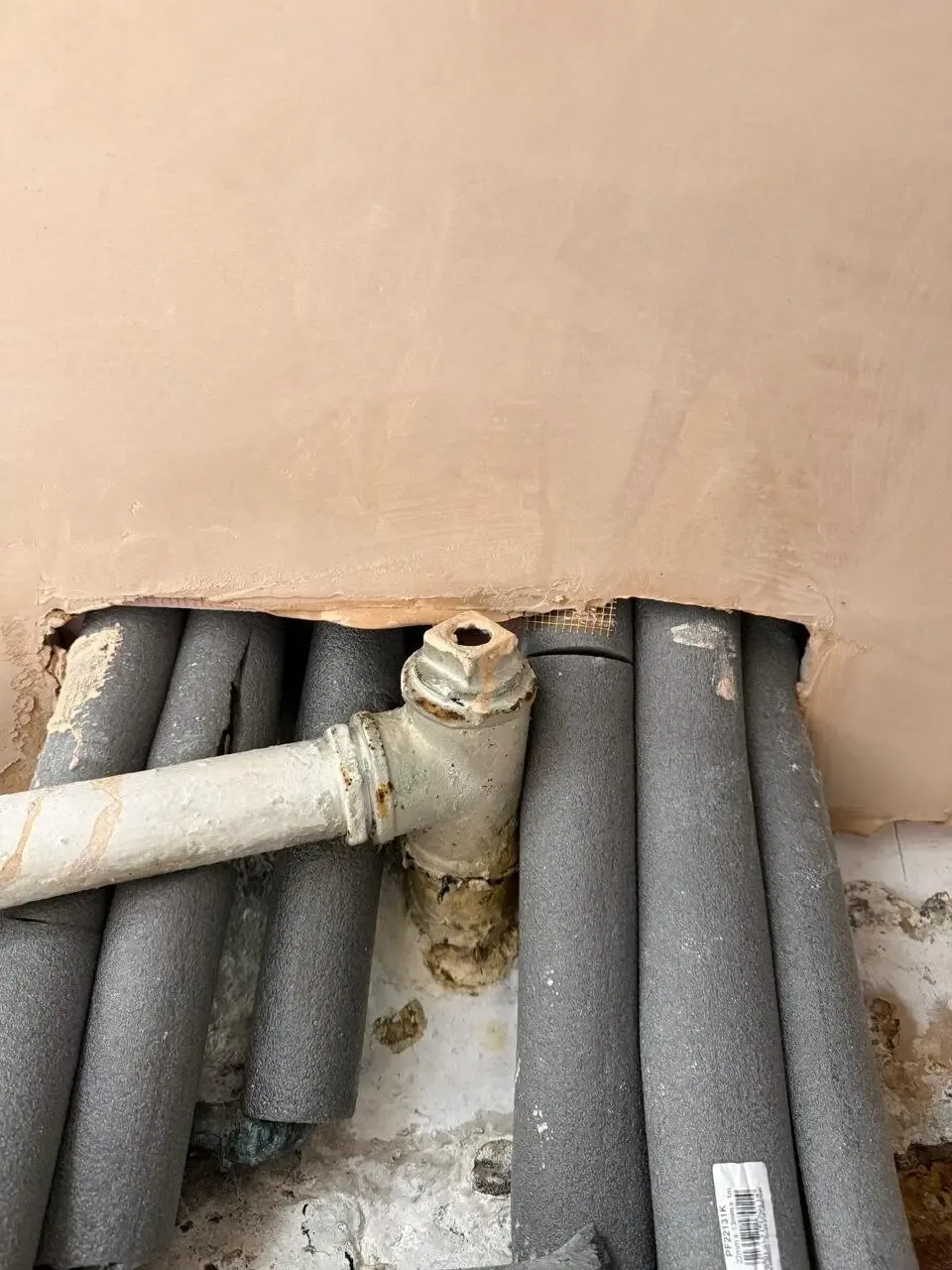 Pipe penetration fire stopping — Manchester, Fallowfield M14: multiple pipes passing through an open wall penetration.